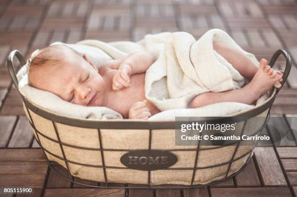 neonato maschio dorme nella cesta. - pavimento di legno stockfoto's en -beelden