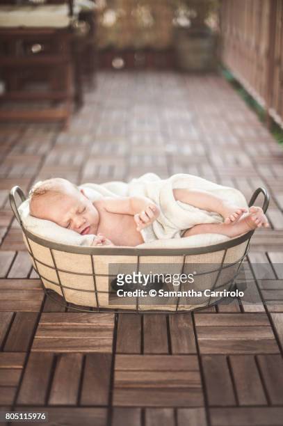 neonato maschio dorme nella cesta. - coprire stockfoto's en -beelden
