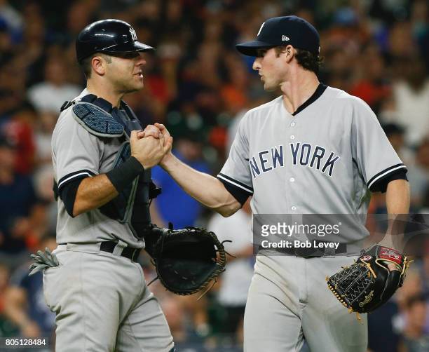 Austin Romine of the New York Yankees shakes hands with Bryan Mitchell after the final out against the Houston Astrosat Minute Maid Park on June 30,...