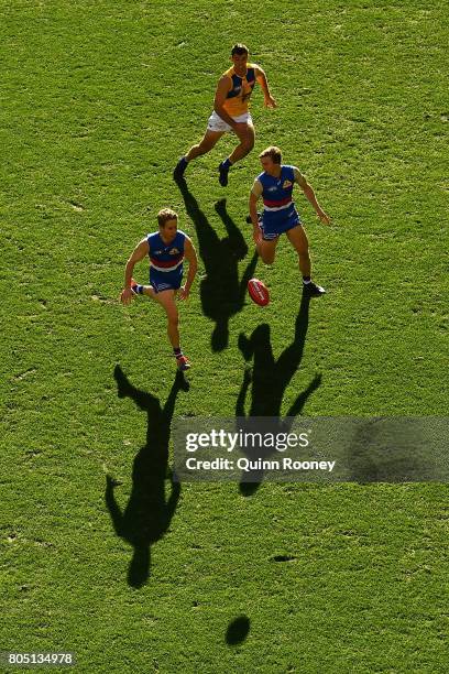 Lachie Hunter of the Bulldogs chases after the ball infront of Mitch Honeychurch of the Bulldogs and Jamie Cripps of the Eagles during the round 15...