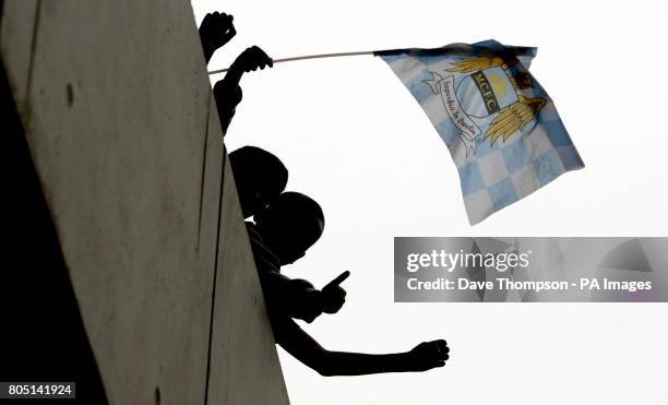 Manchester City fans wait for players to come out for the training session at The City of Manchester Stadium, Manchester.