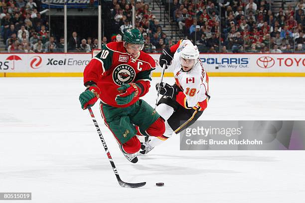 Marian Gaborik of the Minnesota Wild is tripped up by Matthew Lombardi of the Calgary Flames during the game at Xcel Energy Center on April 3, 2008...