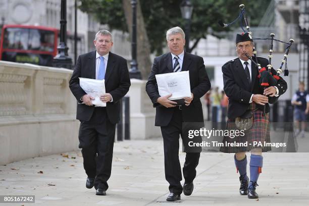 Angus Campbell, Chairman of the Hebrides Range Taskforce, Angus MacMillan, Chairman of Storas Uibhist and piper James MacKay march along Whitehall to...