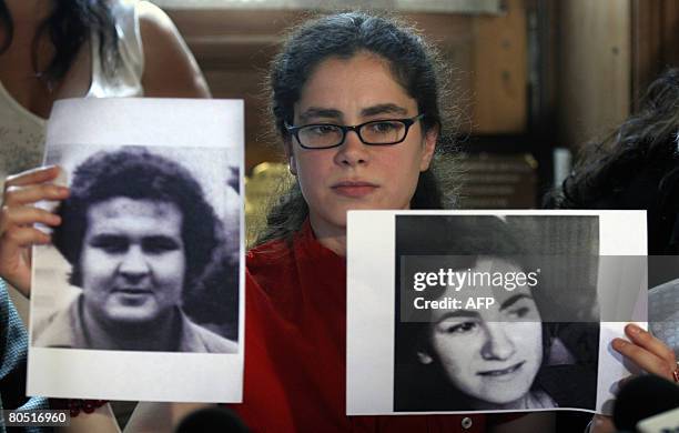Argentinian Maria Eugenia Sampallo Barragan, daughter of "disappeared" people and stolen herself upon birth, shows pictures of her biological fathers...