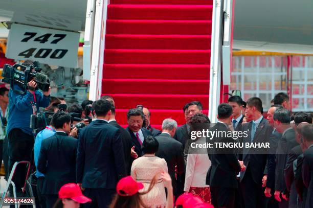 China's President Xi Jinping shakes hands with Hong Kong officials as he prepares to depart from Hong Kong's international airport on July 1, 2017. -...