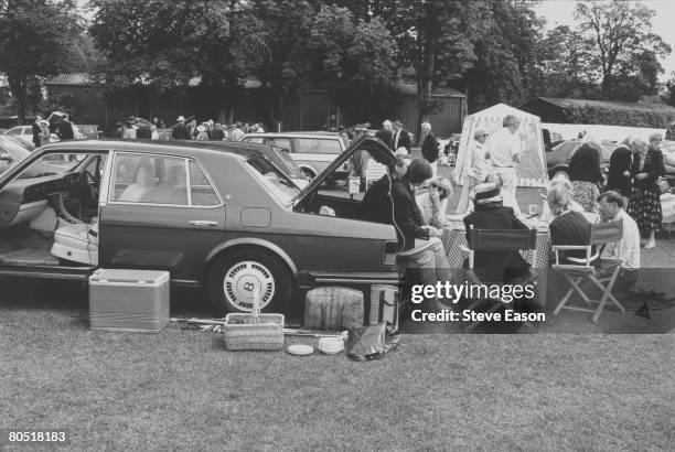 Visitors to the Henley regatta at Henley-on-Thames set up their picnic from the back of their Bentley motor car, 2nd July 1997.