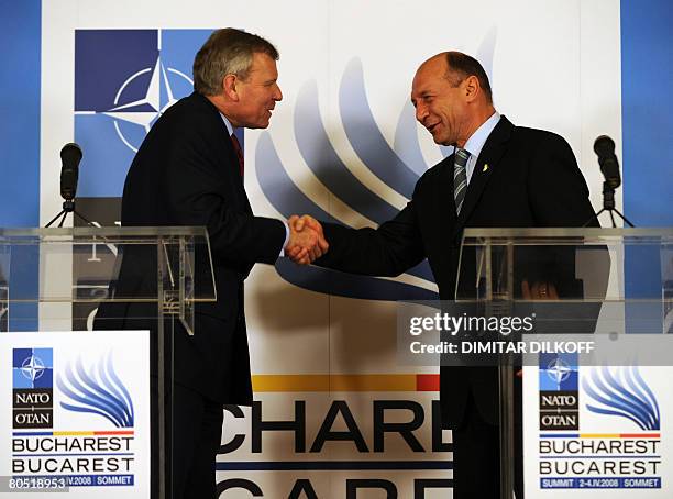 Nato Secretary General Jaap de Hoop Scheffer shakes hands with Romanian President Traian Basescu during their joint news conference on April 1, 2008...