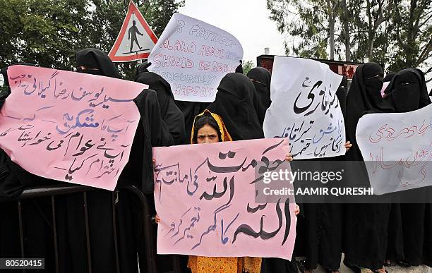 Pakistani veiled female students of radical Red Mosque carry placards as they march during a protest in Islamabad on April 4, 2008. They were...