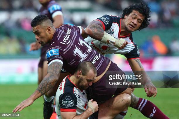 Frank Winterstein of the Sea Eagles spins out of a tackle by James Gavet and Simon Mannering of the Warriors during the round 17 NRL match between...