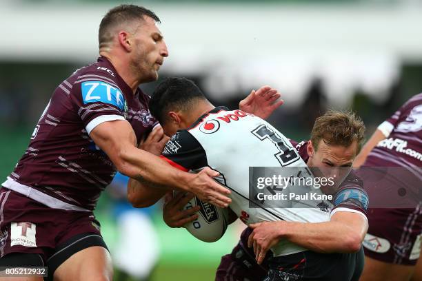 Roger Tuivasa-Sheck of the Warriors gets tackled by Lewis Brown and Daly Cherry-Evans of the Sea Eagles during the round 17 NRL match between the...