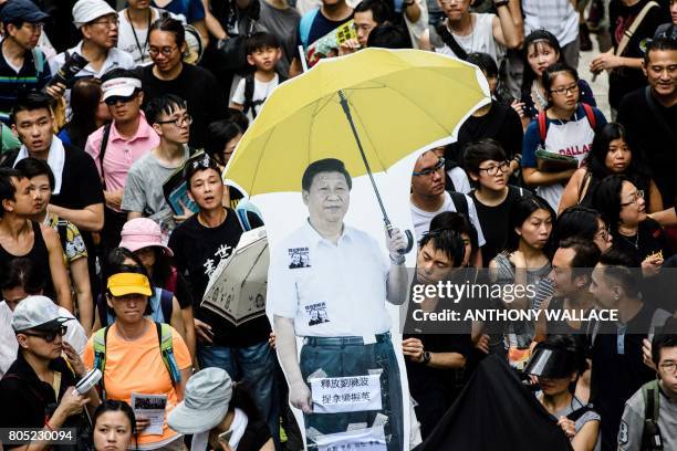 Cardboard cut-out of China's President Xi Jinping holding a yellow umbrella, a symbol of the 2014 'Umbrella Movement', is carried during a protest...