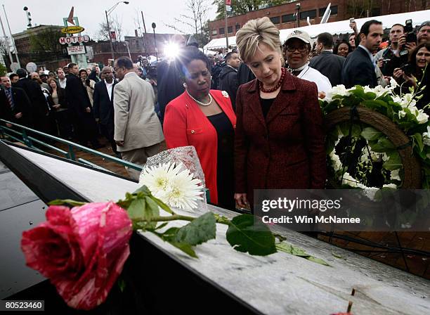 Democratic presidential candidate Sen. Hillary Clinton reads a plaque covered with flowers commemorating Martin Luther King Jr. Outside the Lorraine...