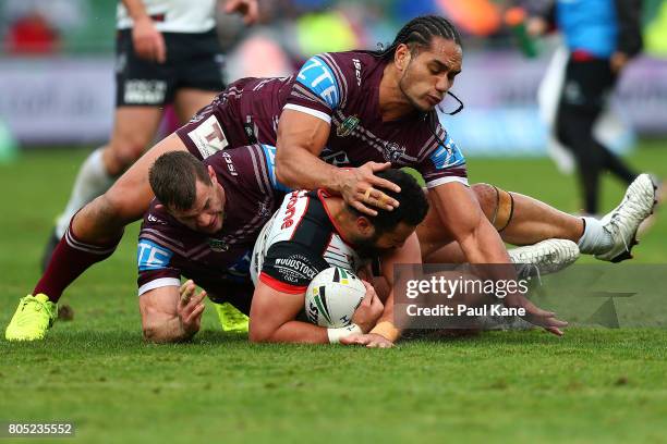 Ben Matulino of the Warriors gets tackled by Martin Taupau and Brenton Lawrence of the Sea Eagles during the round 17 NRL match between the Manly Sea...