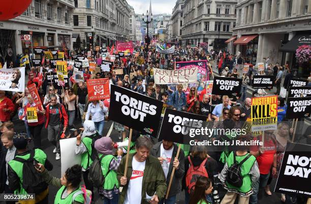 Demonstrators carry placards during the 'Not One Day More' march through London's West End on July 1, 2017 in London, England. Thousands of...