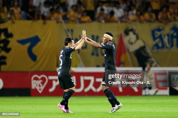 Fabio of Gamba Osaka celebrates scoring his side's third goal with his team mate Jungo Fujimoto during the J.League J1 match between Vegalta Sendai...