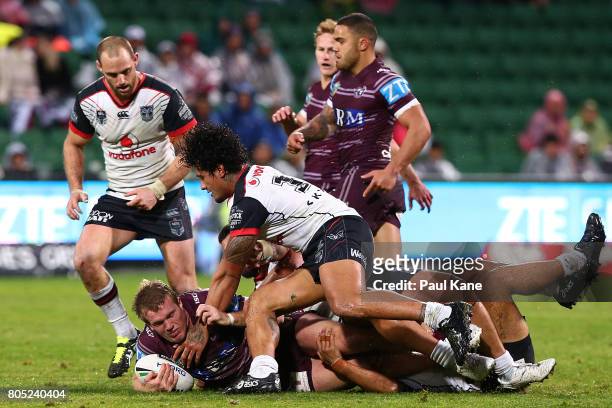 Jake Trbojevic of the Sea Eagles gets tackled by James Gavet and Ben Matulino of the Warriors during the round 17 NRL match between the Manly Sea...