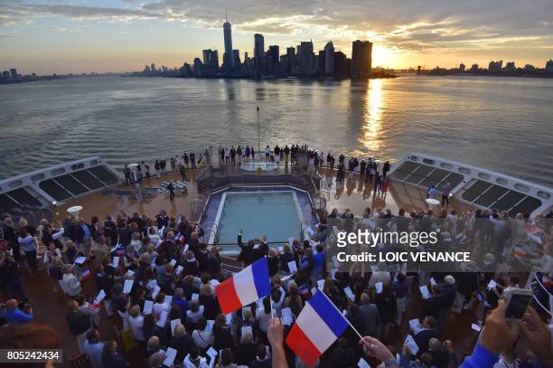 French chief Jean-Christophe Spinosi leads a choral of passengers aboard the Cunard cruise liner RMS Queen Mary 2 as it arrives in New York during...