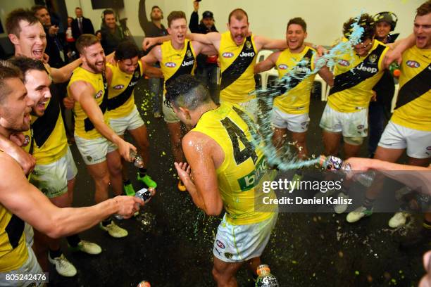 Tyson Stengle of the Tigers receives a gatorade shower from his team mates as they sing the club song after the round 15 AFL match between the Port...
