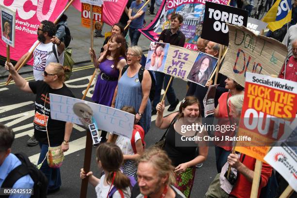 Demonstrators carry placards during the 'Not One Day More' march on Regent Street on July 1, 2017 in London, England. Thousands of protesters joined...