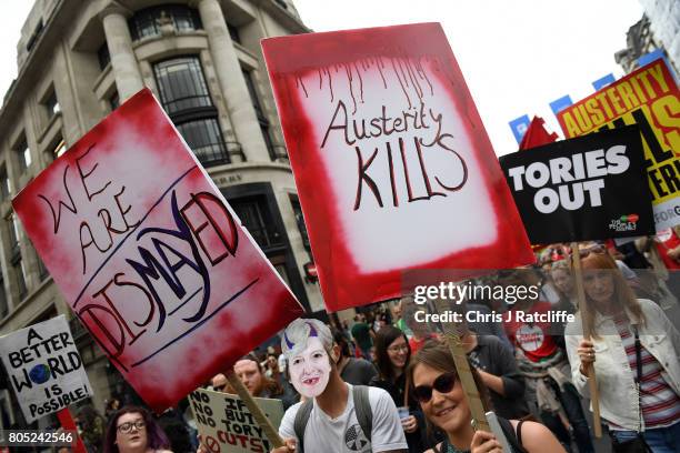 Demonstrators carry placards during the 'Not One Day More' march on Regent Street on July 1, 2017 in London, England. Thousands of protesters joined...