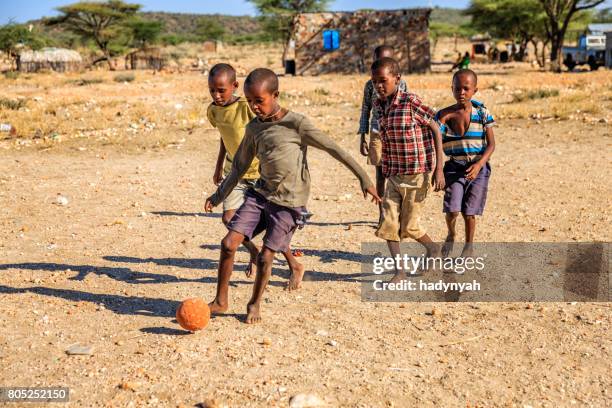 barefoot african children playing football in the village, east africa - barefeet soccer stock pictures, royalty-free photos & images