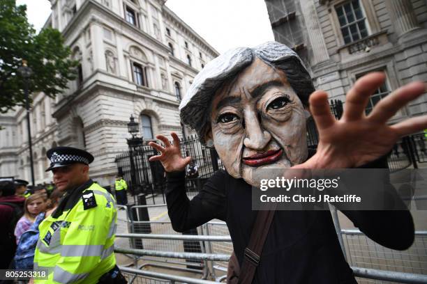 Protester wears a Theresa May mask during the 'Not One Day More' march outside of Downing Street on July 1, 2017 in London, England. Thousands of...