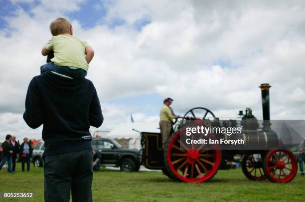 Man and his son watch as a steam engine is driven into the arena during the Duncombe Park Steam Rally on July 1, 2017 in Helmsley, United Kingdom....