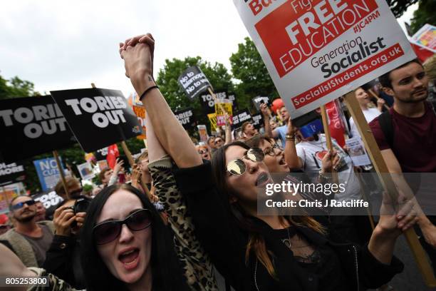 Demonstrators carry placards during the 'Not One Day More' march outside Downing Street on July 1, 2017 in London, England. Thousands of protesters...