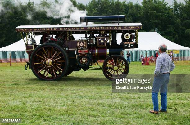 Man watches as a steam engine is driven across the showground during the Duncombe Park Steam Rally on July 1, 2017 in Helmsley, United Kingdom. Held...