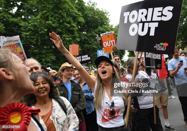 Demonstrators carry placards during the 'Not One Day More' march outside Downing Street on July 1, 2017 in London, England. Thousands of protesters...