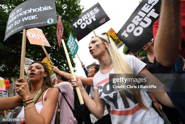 Demonstrators carry placards during the 'Not One Day More' march on July 1, 2017 in London, England. Thousands of protesters joined the anti-Tory...