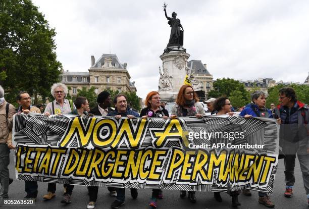 People hold a banner reading "no to the permanent state of emergency", during a demonstration against the state of emergency on Place de la...