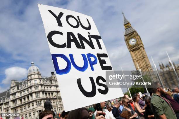 Demonstrators carry placards during the 'Not One Day More' march at Parliament Square on July 1, 2017 in London, England. Thousands of protesters...