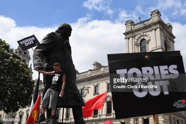Demonstrator climbs the Statue of Winston Churchill as he waits for Labour Party leader, Jeremy Corbyn to speak during the 'Not One Day More' march...