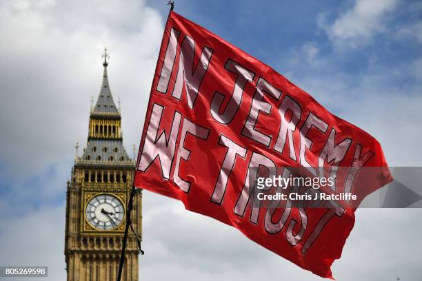 Flag supporting Labour Party leader, Jeremy Corbyn flies with Big Ben in the background during the 'Not One Day More' march at Parliament Square on...