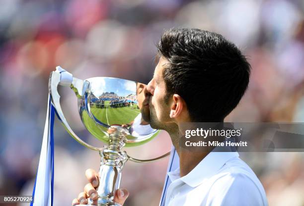 Novak Djokovic of Serbia kisses the trophy after victory in the mens singles final against Gael Monfils of France on day seven of the Aegon...