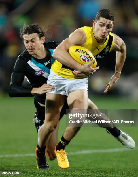 Jason Castagna of the Tigers is tackled by Jasper Pittard of the Power during the 2017 AFL round 15 match between the Port Adelaide Power and the...