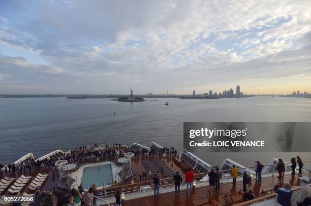 The Statue of Liberty is seen in the distance as the Cunard cruise liner RMS Queen Mary 2 arrives in New York after passing under the Verrazano...