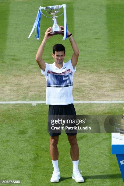 Novak Djokovic of Serbia raise the trophy after victory during the Final match against Gael Monfils of France on day seven on July 1, 2017 in...