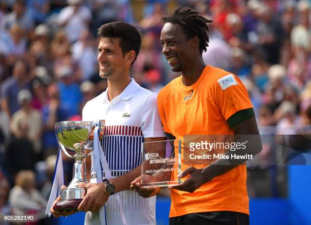 Champion Novak Djokovic of Serbia poses with with the trophy alongside Gael Monfils of France after victory in the mens singles final on day seven of...