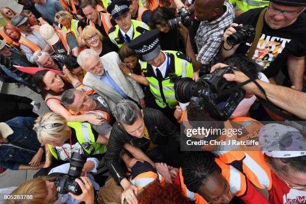 Labour Party leader Jeremy Corbyn is escorted through the crowd by police after speaking to demonstrators during the 'Not One Day More' march at...