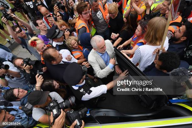 Labour Party leader Jeremy Corbyn is escorted through the crowd by police after speaking to demonstrators during the 'Not One Day More' march at...