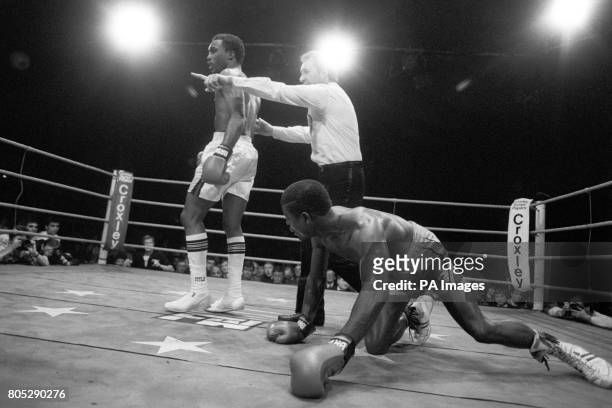 Coventry's Errol Christie on his hands and knees after a knock down as referee Mike Jacobs ushers American Charlie Boston to the neutral corner after...