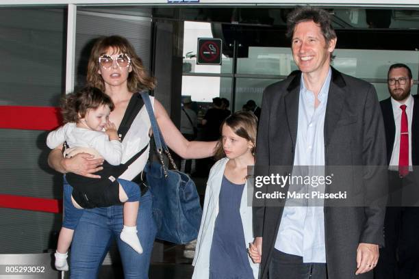 Actress Milla Jovovitch, her daughters Dashiel Edan Anderson and Ever Gabo Anderson and her husband Paul W.S. Anderson arrive at Charles-de-Gaulle...