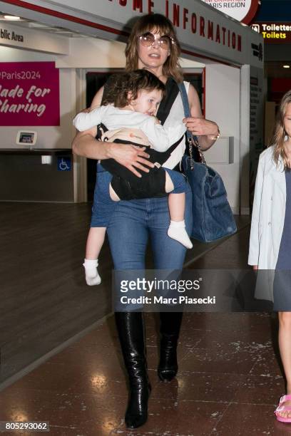 Actress Milla Jovovitch and her daughter Dashiel Edan Anderson arrive at Charles-de-Gaulle airport on July 1, 2017 in Paris, France.