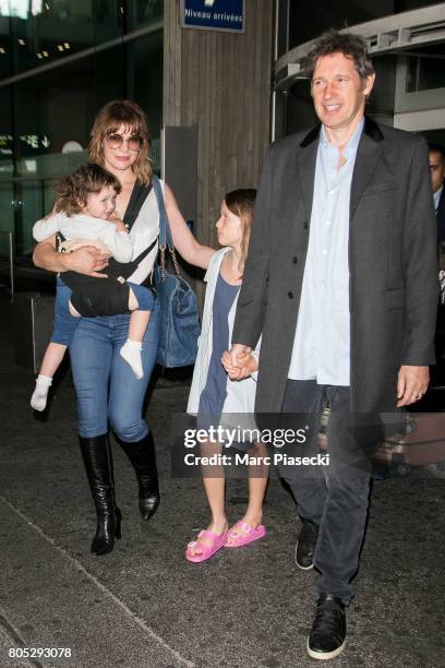 Actress Milla Jovovitch, her daughters Dashiel Edan Anderson and Ever Gabo Anderson and her husband Paul W.S. Anderson arrive at Charles-de-Gaulle...