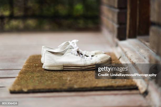 sneakers shoes on a porch - white shoes stock-fotos und bilder