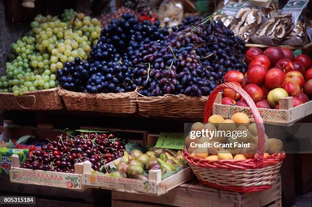 a fruitstand on main walkway displayed in street. - black cherries stock pictures, royalty-free photos & images