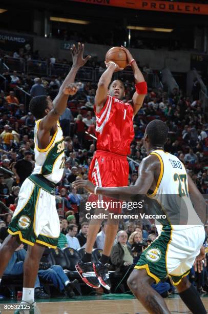 Tracy McGrady of the Houston Rockets shoots over the defense of Jeff Green and Johan Petro of the Seattle SuperSonics on April 4, 2008 at the Key...