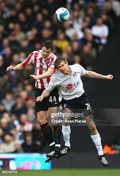 Jonny Evans of Sunderland jumps for a header with Brian McBride of Fulham during the Barclays Premier League match between Fulham and Sunderland at...